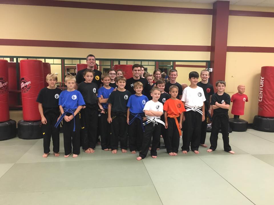 A group of students in uniform with their instructors at the academy